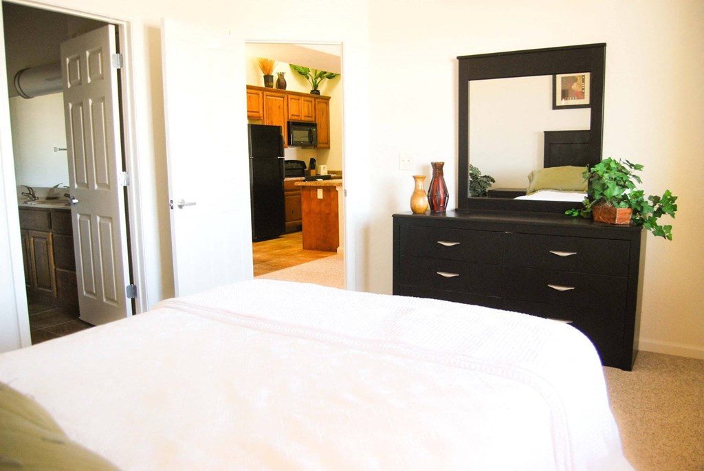 a bedroom with a bed and a dresser with a mirror