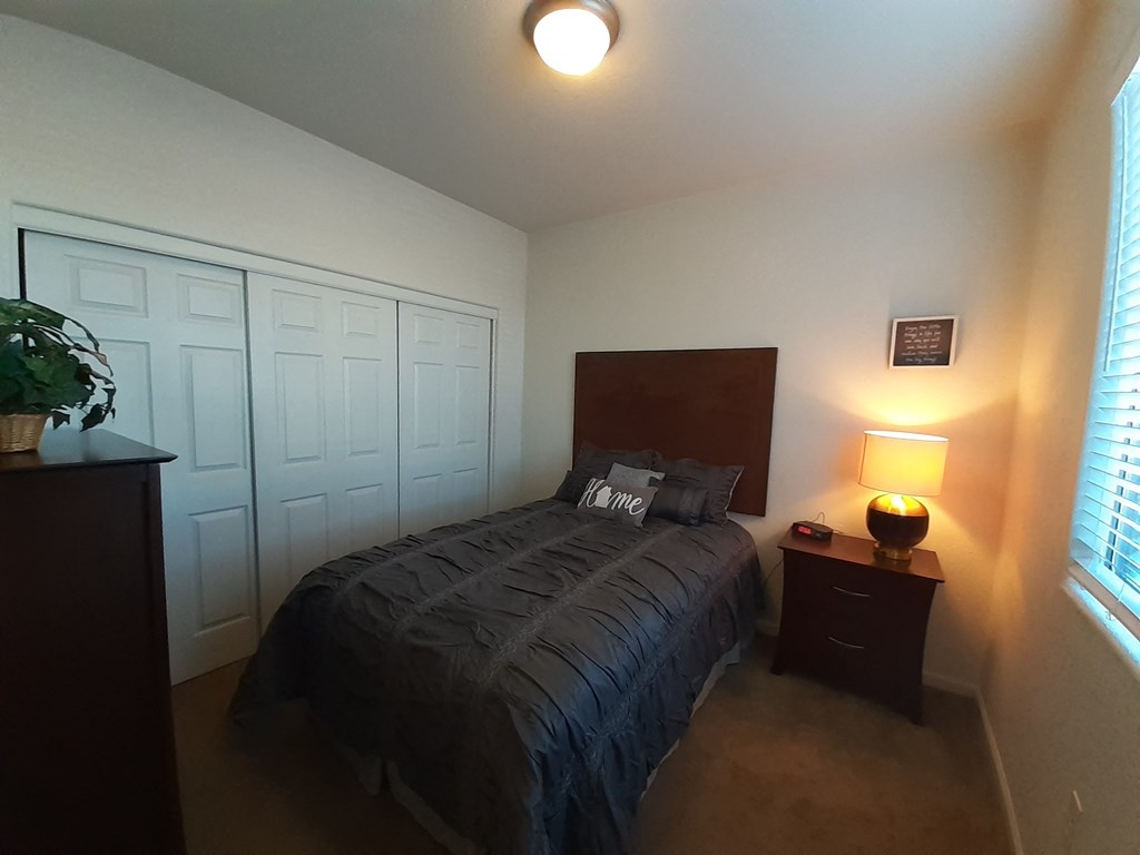 a bedroom with a bed and a dresser and a window