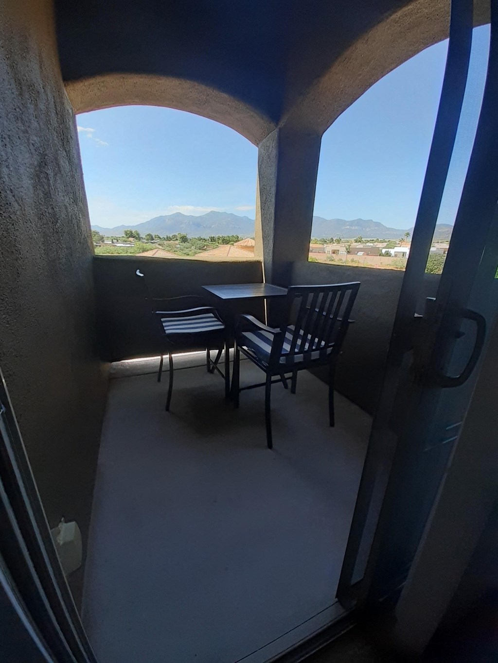 a balcony with a table and chairs and a view of the mountains