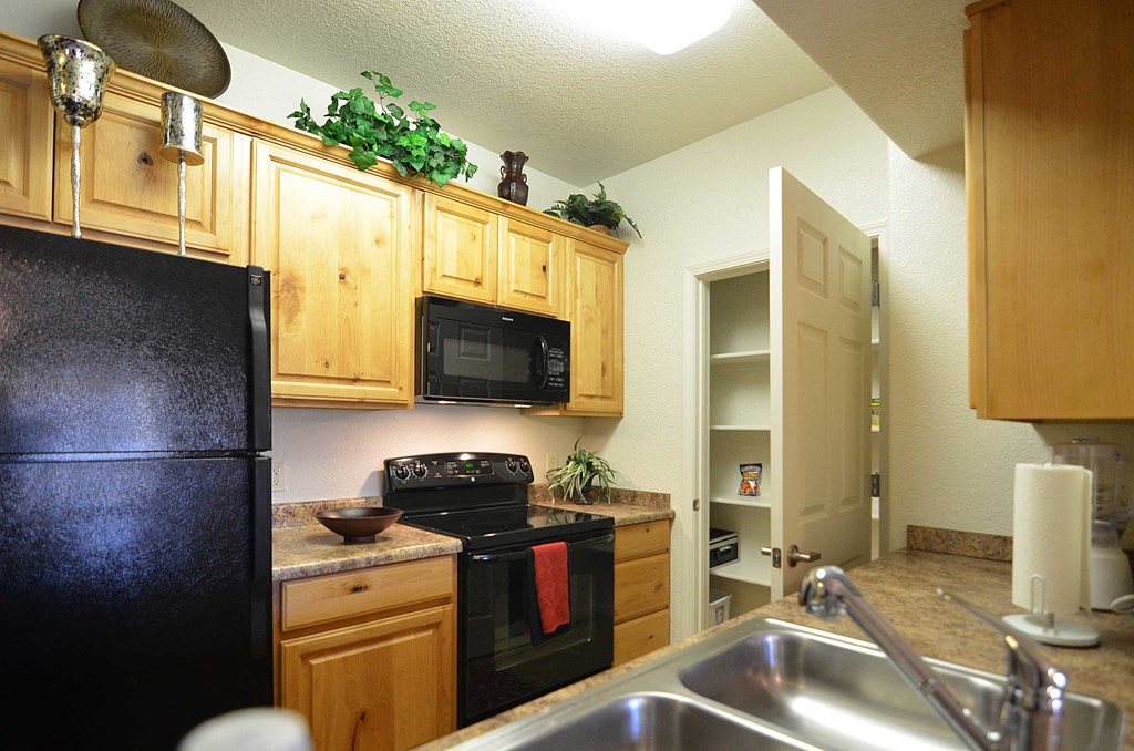 a kitchen with black appliances and wooden cabinets