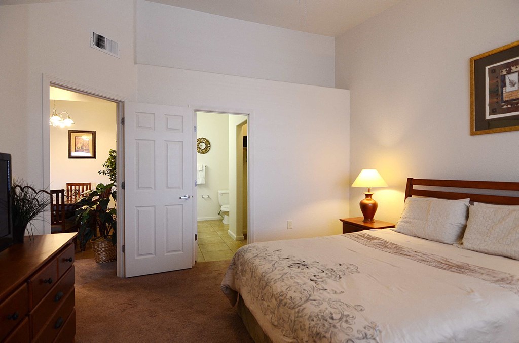 a bedroom with a bed and a door to a bathroom