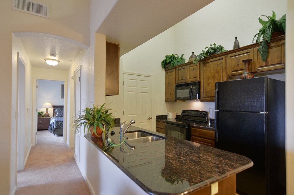 a kitchen with black appliances and granite counter tops