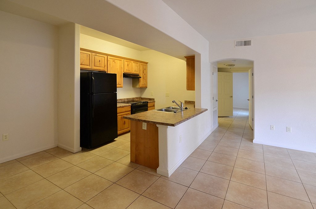 a kitchen with a counter top and a black refrigerator