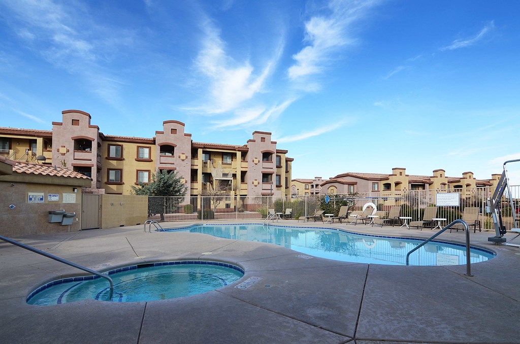 a swimming pool with an apartment building in the background