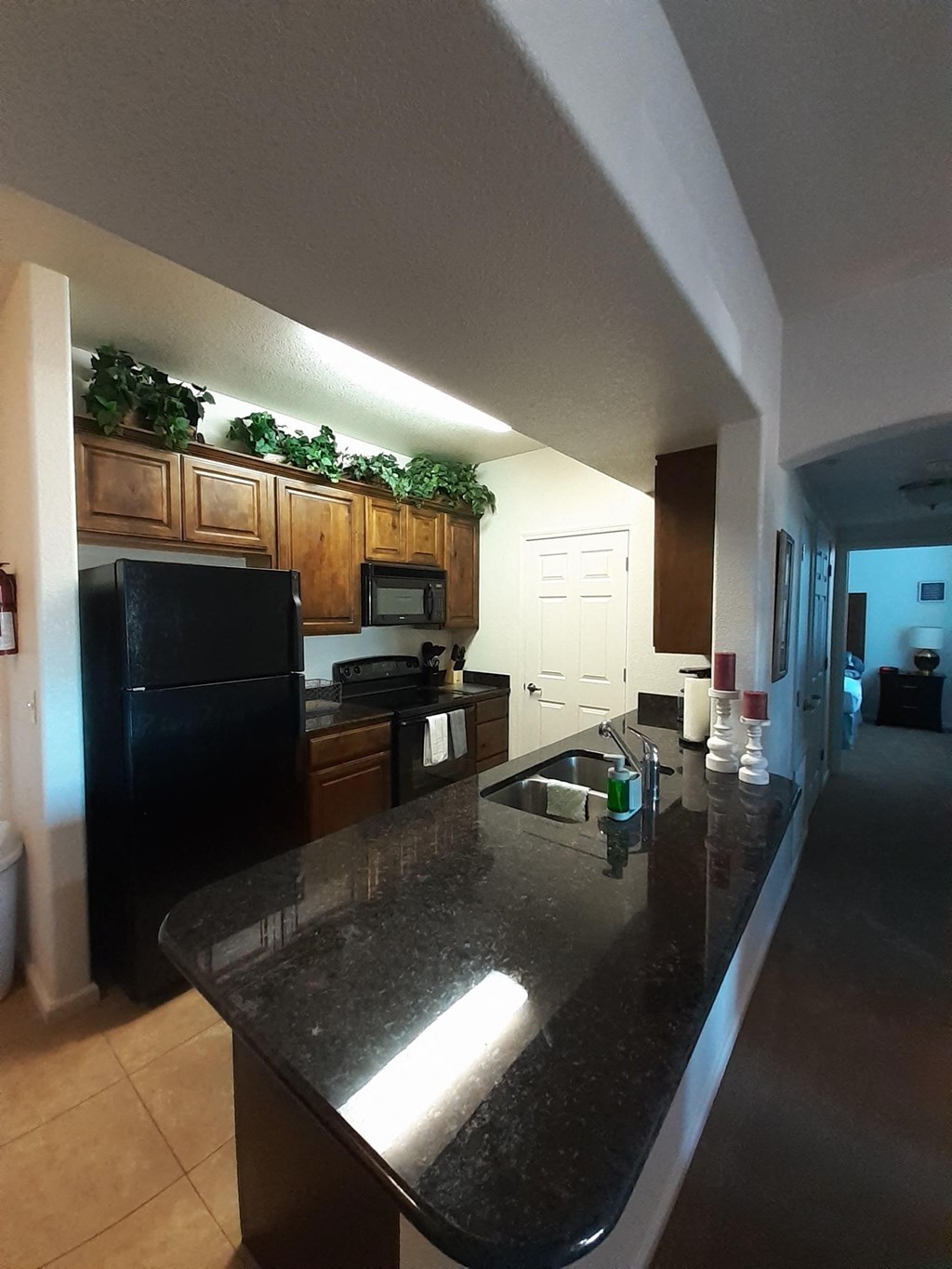 a kitchen with a granite counter top and black appliances