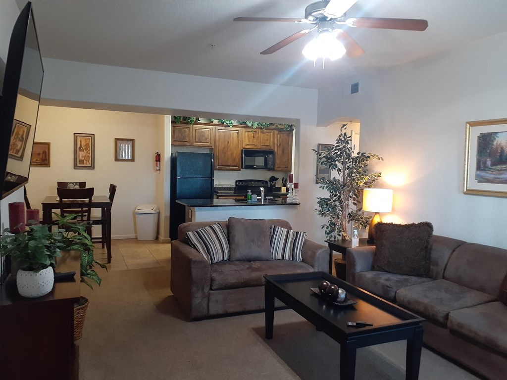 an open living room and kitchen with a ceiling fan