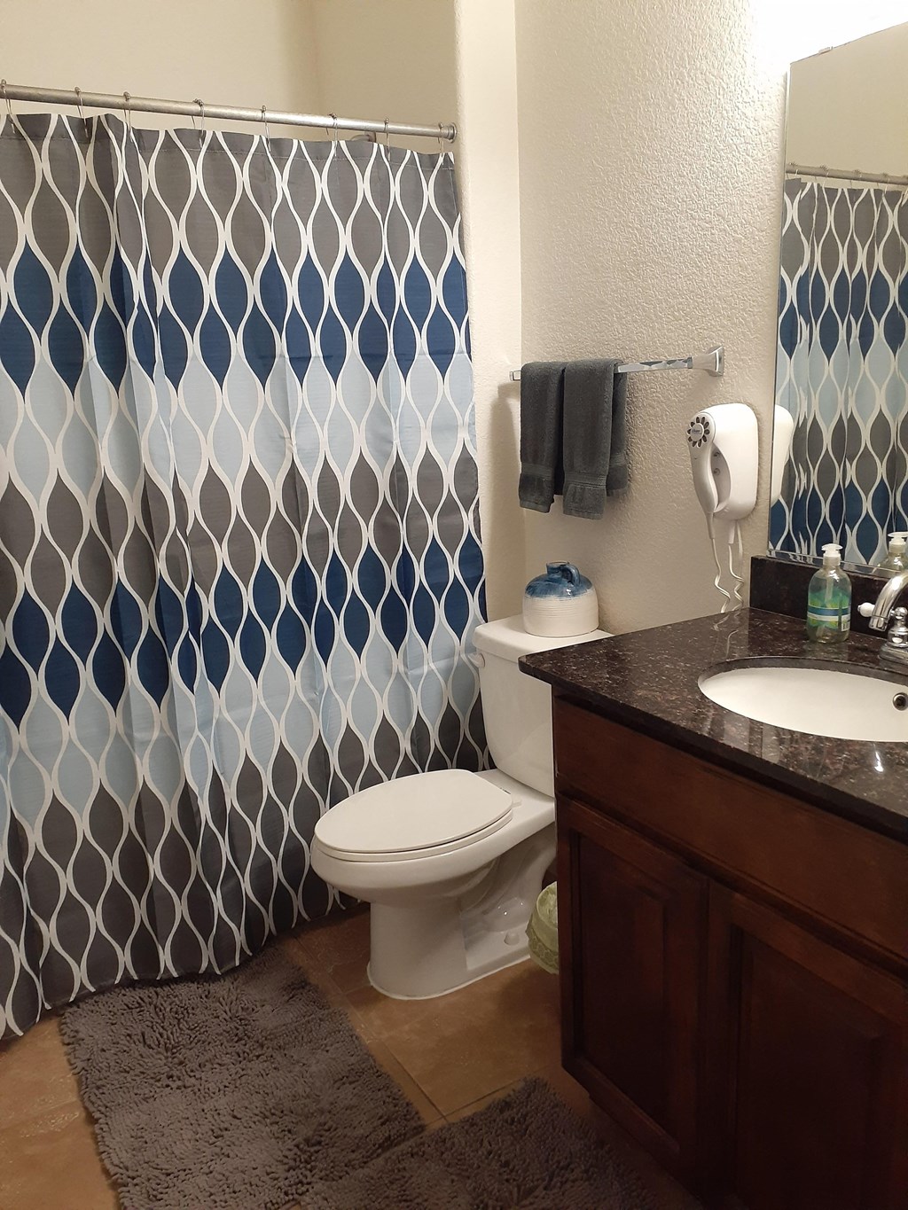 a bathroom with a shower and a toilet and a sink