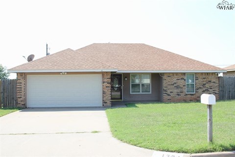 A house with a garage door and a mailbox in front.