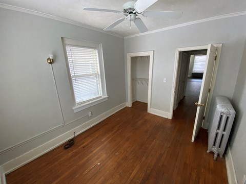 a living room with wood floors and a ceiling fan
