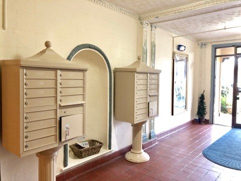 A series of mailboxes are lined up on a wall.