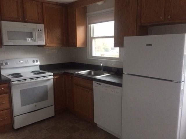 a kitchen with a stove refrigerator and a sink