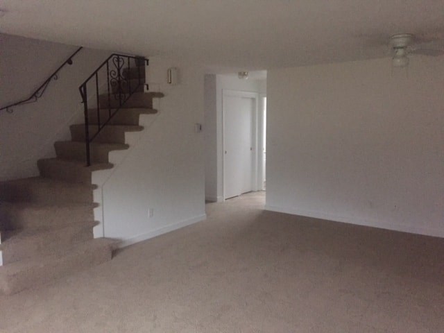 an empty living room and stairs in a house