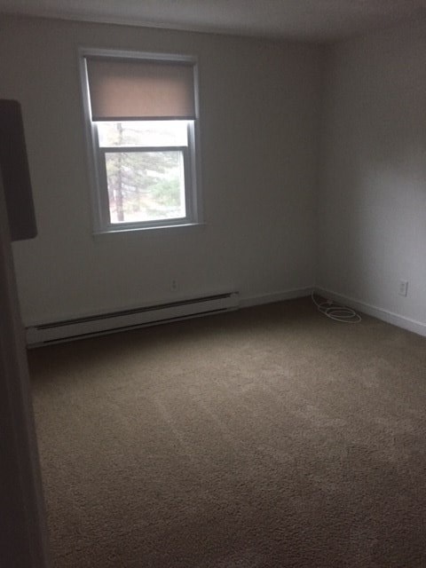 an empty room with a window and a carpet