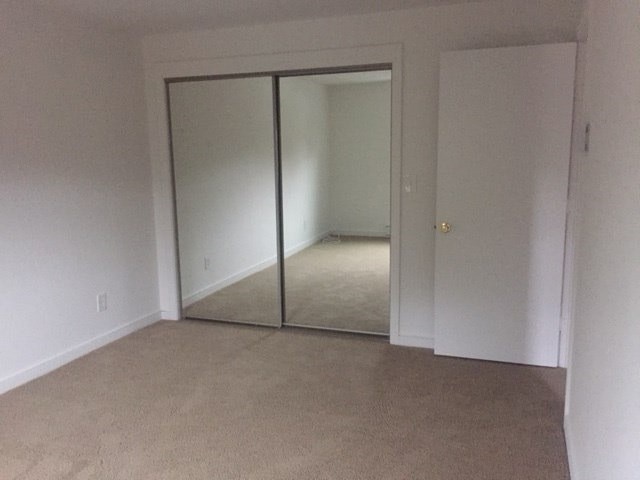 an empty living room with a mirror in it