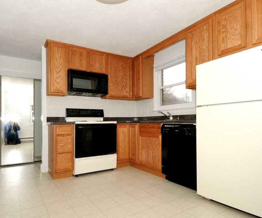 a kitchen with black and white appliances and wooden cabinets