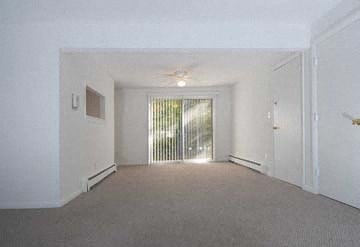 an empty living room with a door to a balcony