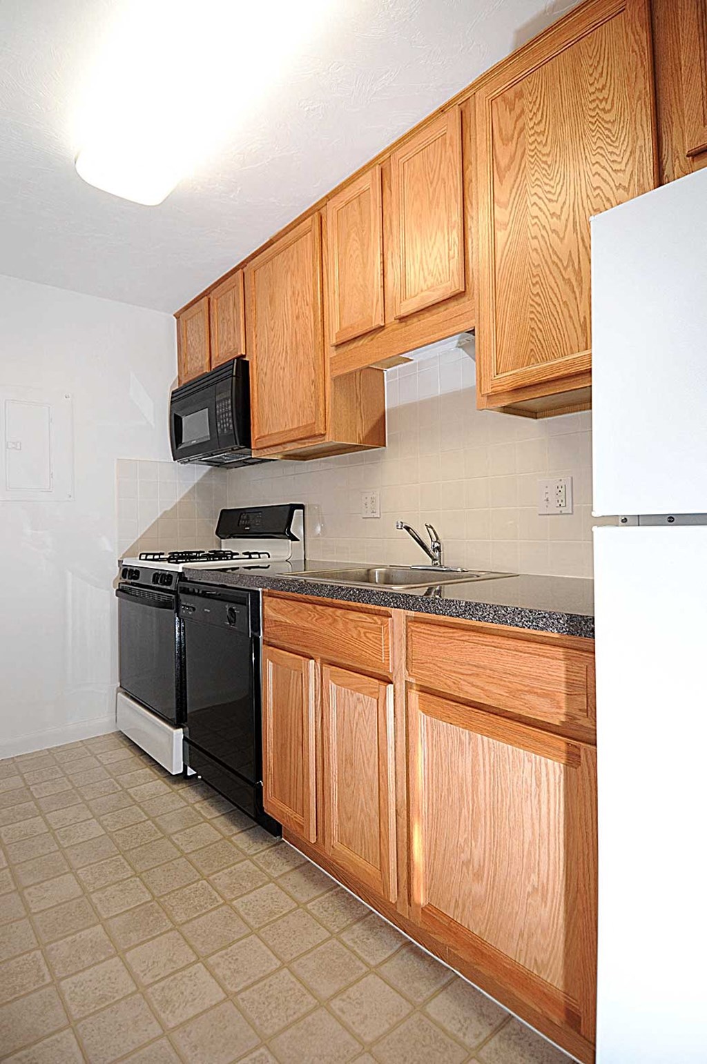 a kitchen with black appliances and wooden cabinets