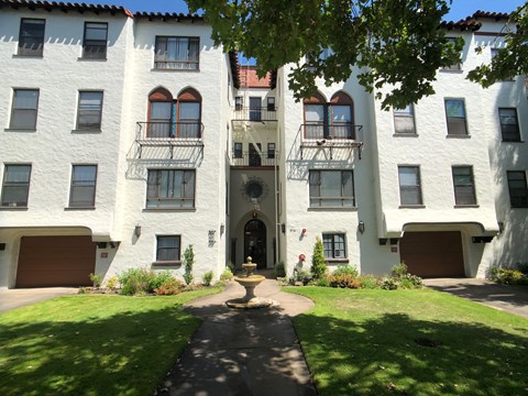 A white building with a brown door and windows.