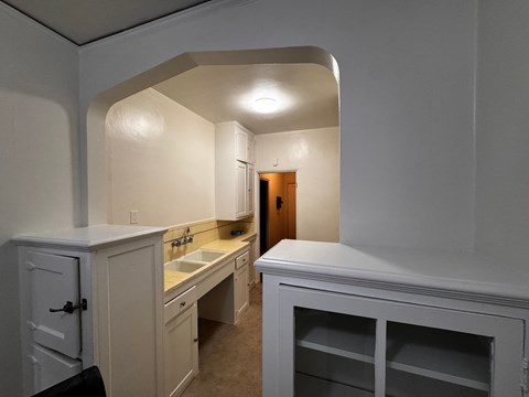 A kitchen with white cabinets and a sink.