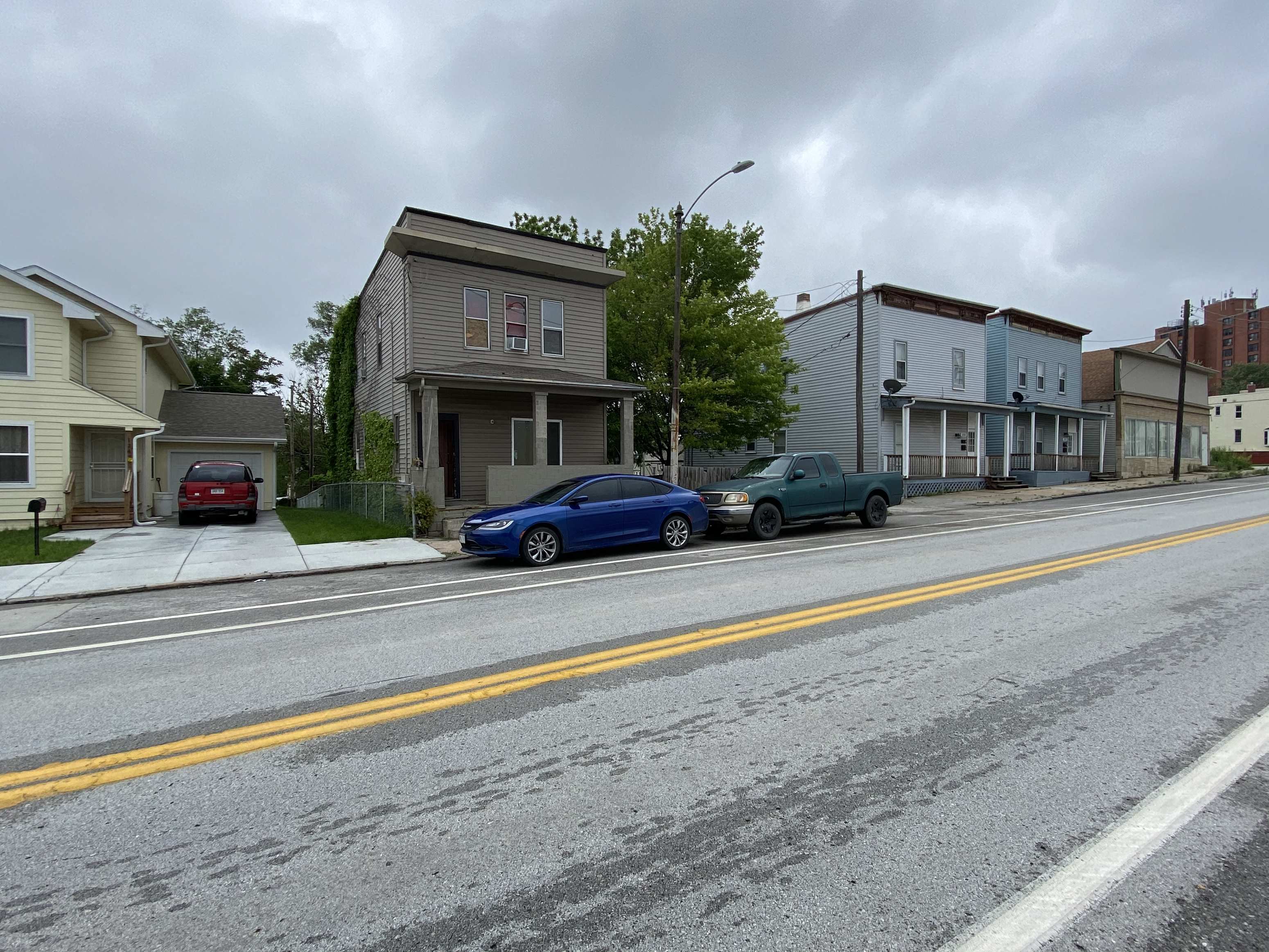 A blue car is parked on the side of a street.