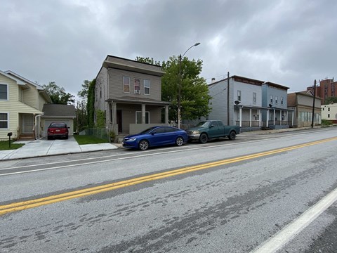 A blue car is parked on the side of a street.