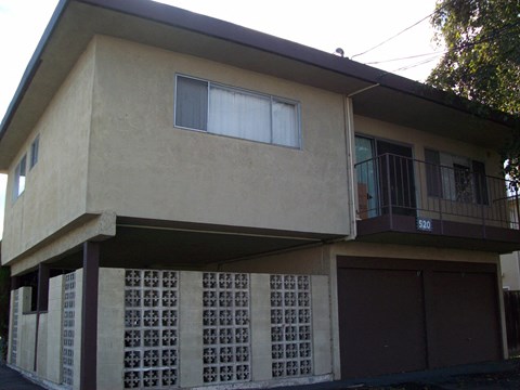 A two-story house with a balcony on the second floor.