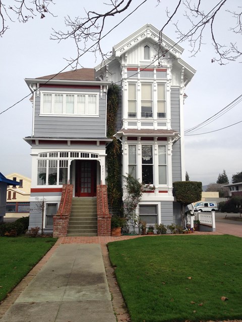A two-story house with a red door and white trim.