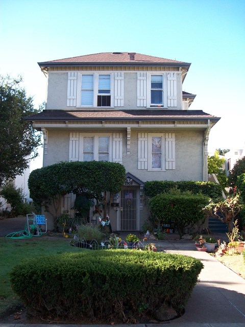 A house with a grey facade and white shutters.
