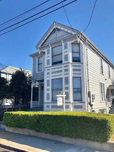 A two-story house with a grey facade and white trim.