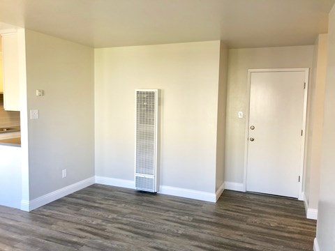 A room with a white door and a window with blinds.