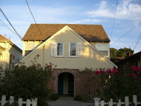 A house with a white fence and a green door.