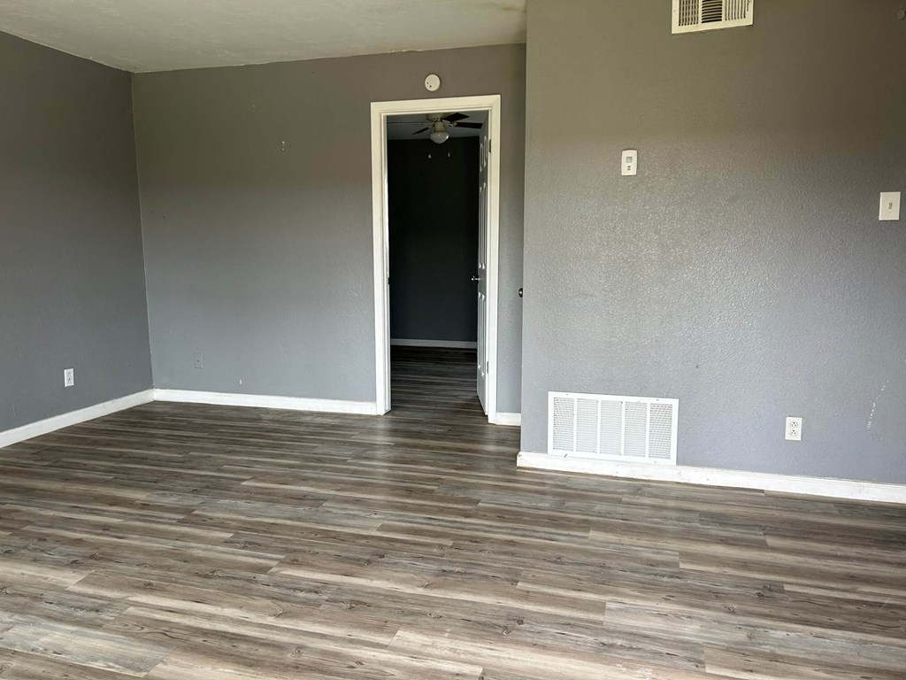 a living room with wood floors and grey walls and a door