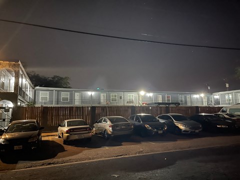a row of cars parked in front of a building at night