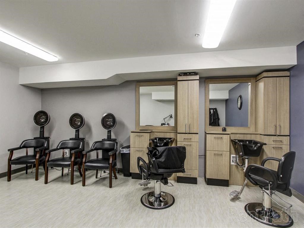 a salon room with chairs and a counter and a mirror