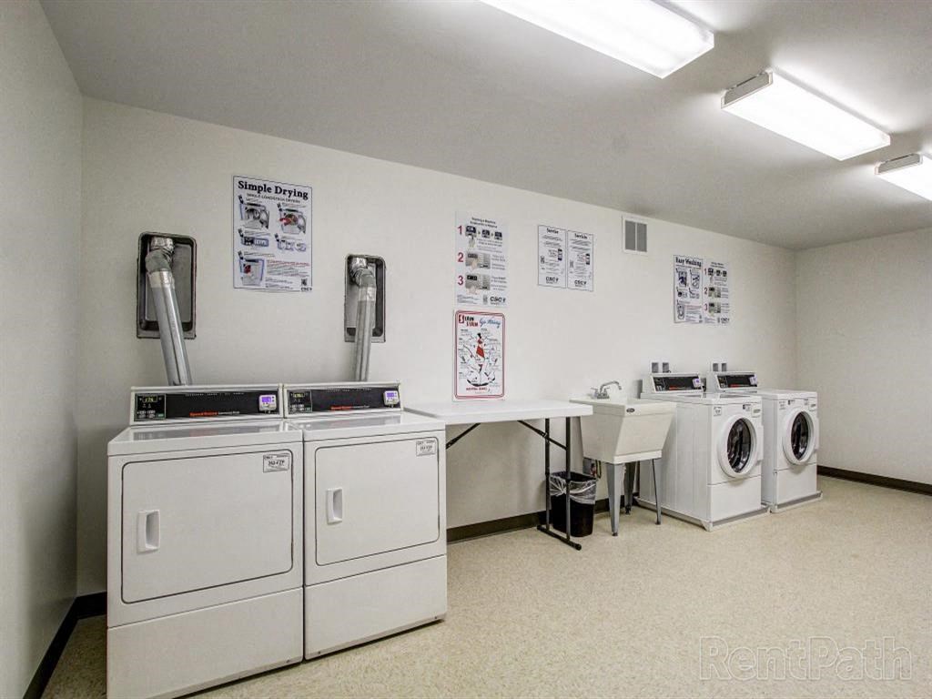 a laundry room with washes and dryers and a table