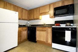 a kitchen with black and white appliances and wooden cabinets