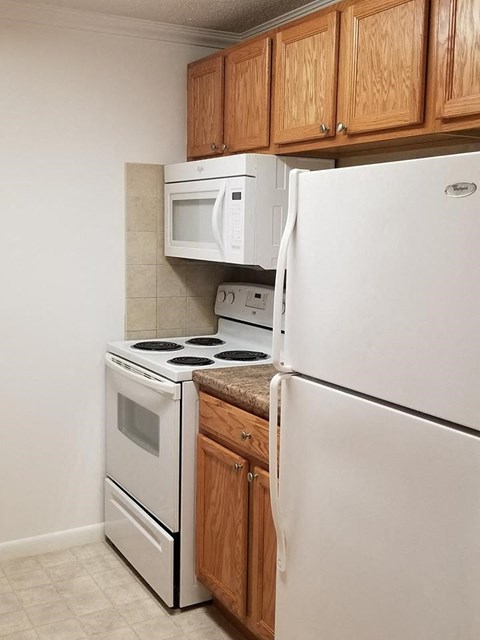 a kitchen with a stove refrigerator and microwave