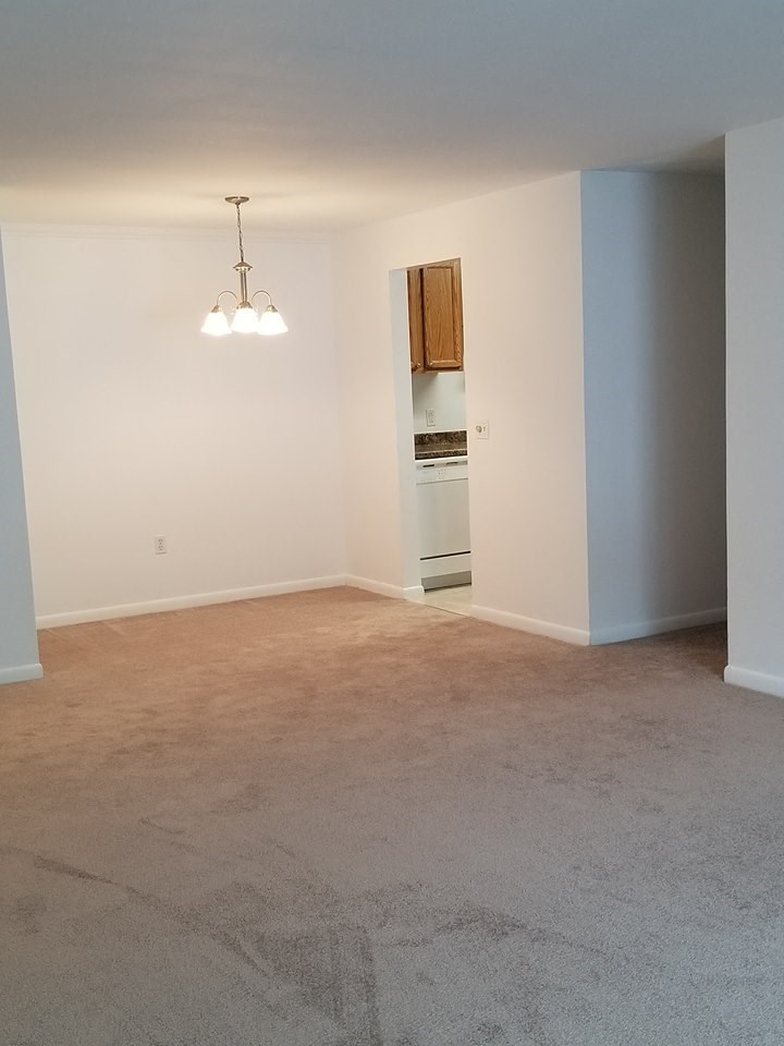an empty living room with white walls and a carpet