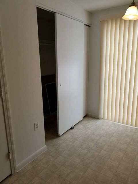 an empty living room with a door to a closet