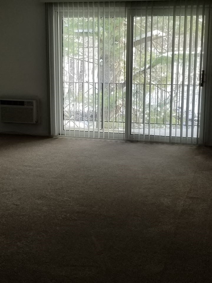 an empty living room with sliding glass doors