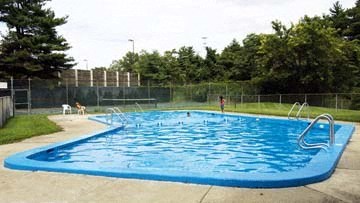 a large blue swimming pool with people in it