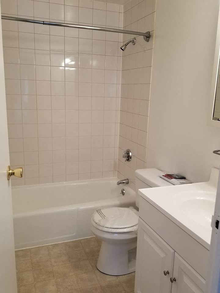a bathroom with a toilet and a tub and a sink
