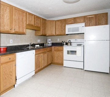 a kitchen with white appliances and wooden cabinets