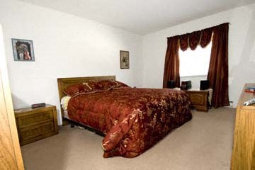 a bedroom with a bed with a red comforter