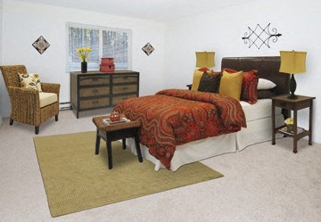 a bedroom with a bed and two chairs