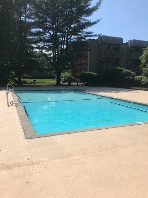a swimming pool in front of an apartment building
