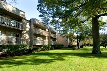 an apartment building with green grass and trees