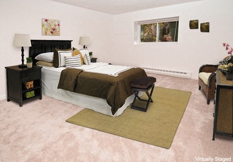 a bedroom with a bed and a couch and a window