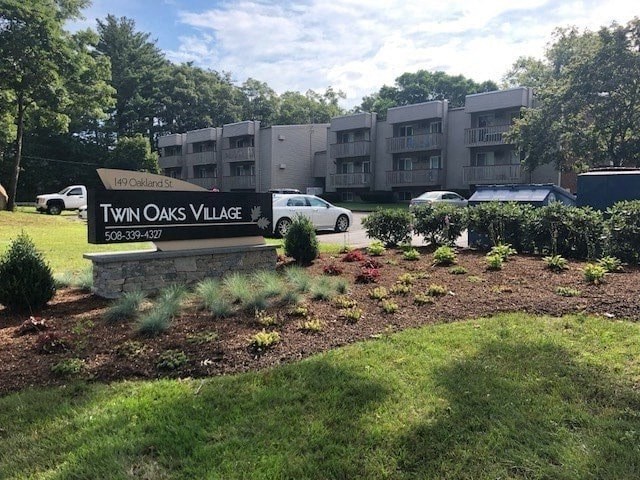 a sign for twin oaks village in front of an apartment building