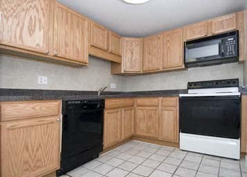 a kitchen with black appliances and wooden cabinets